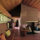 a room with a high sloped ceiling, fireplace, and couch along one wall